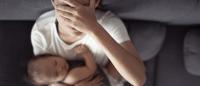 woman with headache holding baby